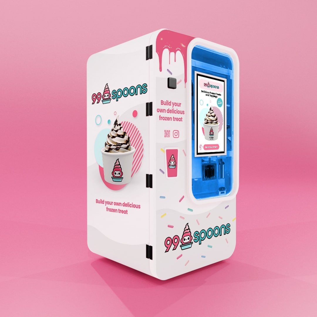 A modern, white frozen treat vending machine with a pink and blue color scheme, branding for "99 spoons," and interactive screens displaying menu options.